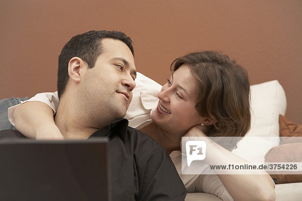 Young couple on couch surfing the internet
