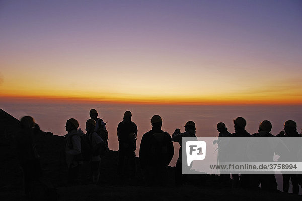 Twilight silhouette of hikers climbing the active volcano on Stromboli Island  Aeolian Islands  Southern Italy