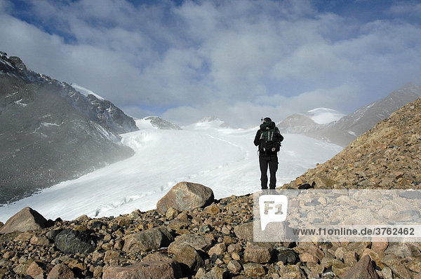 Bergsteiger steht auf Geröll vor Gletscher Kharkhiraa Mongolischer Altai bei Ulaangom Uvs Aimag Mongolei