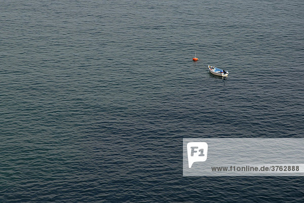 Einzelnes Fischer Boot liegt an Boje am Meer