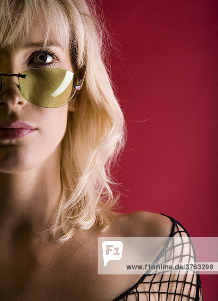 Portraitaufnahme einer jungen  blonden Frau mit Sonnenbrille
