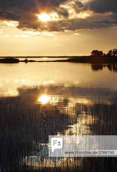Sonnenuntergang am Wasser mit bewaldeten Inseln am Vänernsee in Schweden - Europa