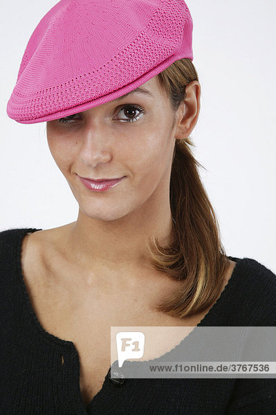 Frau mit pinkfarbener Mütze lächelt
