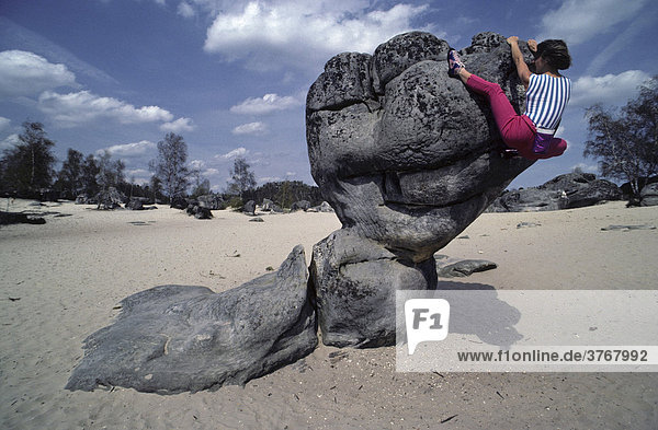 Frau klettert an einer bizarren Felsformation  Fontainebleau  Frankreich