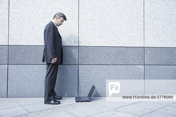 Businessman standing in front of a laptop