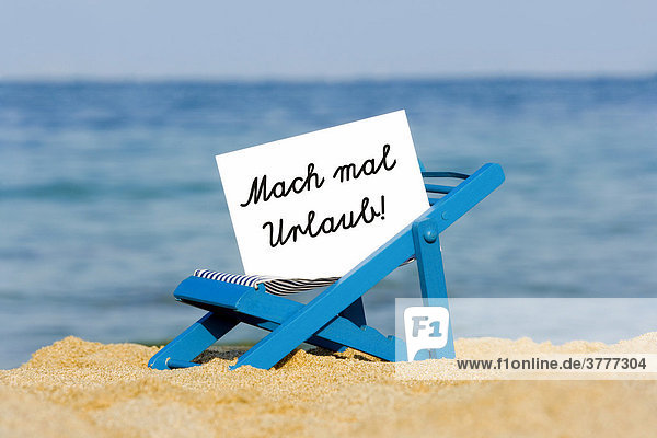 A deckchair with a sign on the beach