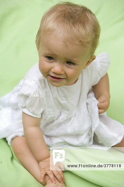 Portrait eines 10 Monate alten Babys auf einer Wolldecke