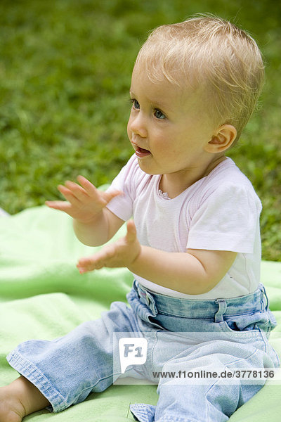 Ein 10 Monate altes Baby beim Spielen auf einer Decke