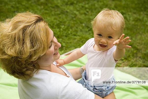 Eine junge Mutter beim Spielen mit ihrer 10 Monate alten Tochter