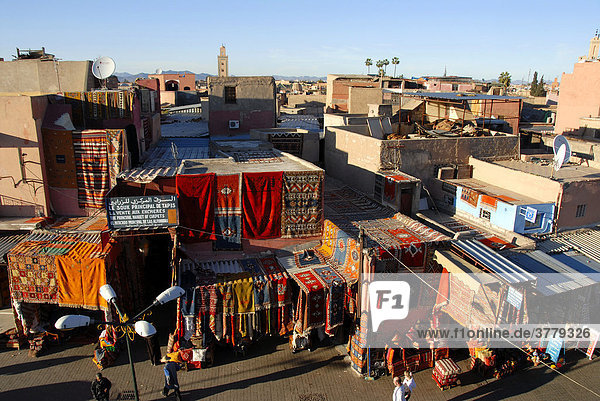 Blick über die Dächer der Stadt Teppiche hängen vor den Fassanden Place Rahba Kedima Medina Marrakech Marokko