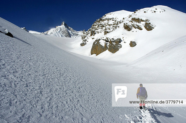 Mountaineer is fighting his way through snow in high mountains Thorung La Pass Annapurna Region Nepal