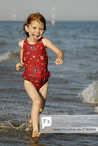 Little girl running along the beach
