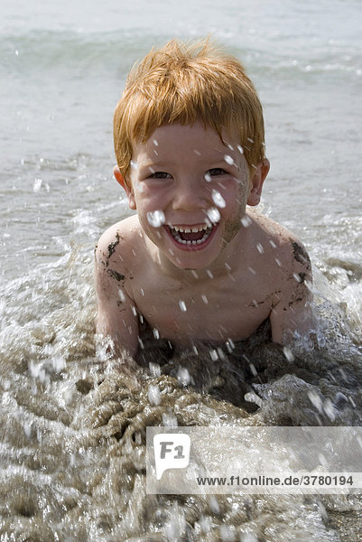 Junge liegt am Meer im Wasser