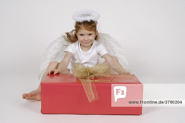 Kleiner Engel an Weihnachten mit einem Geschenk Paket