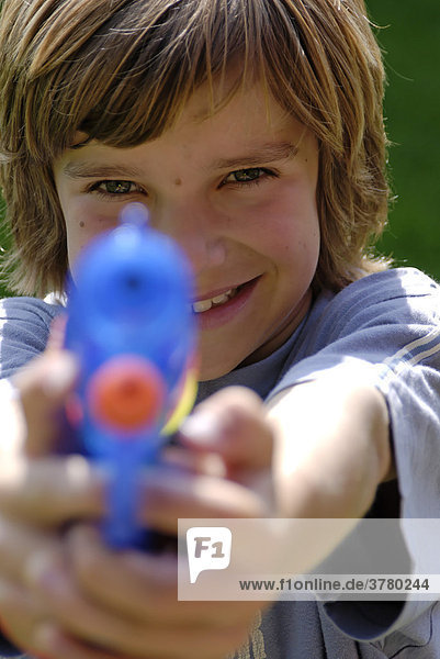 Boy fires with a toy gun pistol