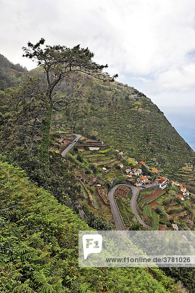 Blick auf die steile Straße und den Küstenort  Porto Moniz  Madeira  Portugal