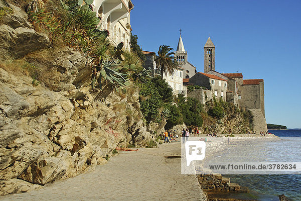 Promenade an der Felsküste mit Blick auf die Kirchentürme der Ortschaft Rab  Insel Rab  Kvarner  Kroatien