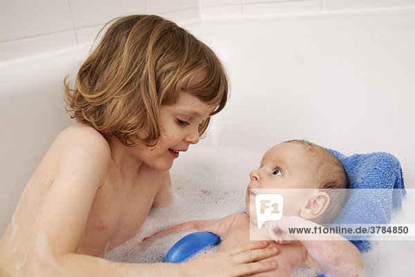 Kleines Mädchen sitzt mit ihrem Bruder in der Badewanne (4 Jahre  2 Monate)