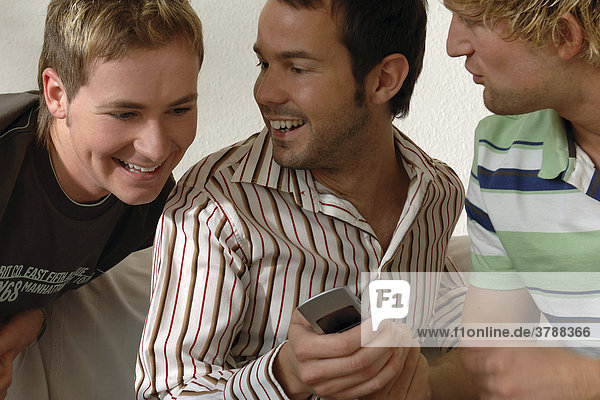 3 young men looking at a mobile phone