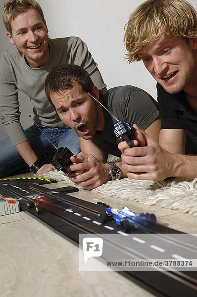 3 young men with Carrera model railway