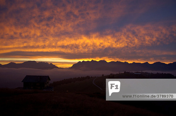 Abendhimmel mit leuchtend rosafarbenen Wolken über Berghütte und Gebirge Hochsavoyen Haute-Savoie Frankreich