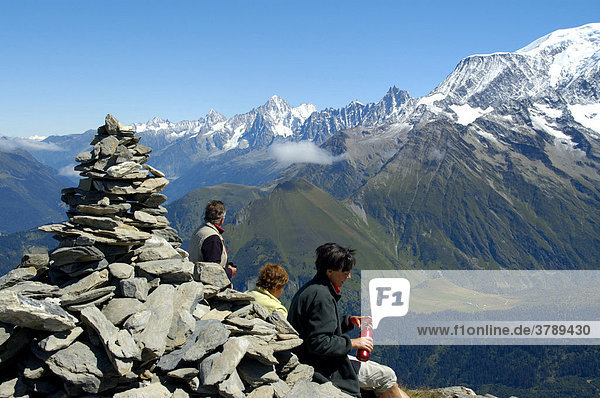 People and stone man on the summit of Mont Joly Haute-Savoie France