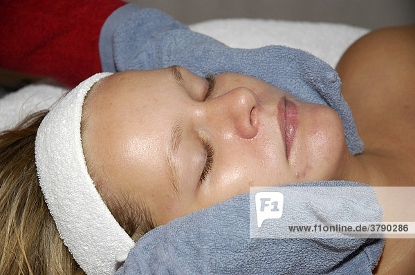 Junge Frau entspannt sich bei einer Massage  Kosmetik  Kosmetikbehandlung  Koerperpflege  Gesichtsmassage  Wellness