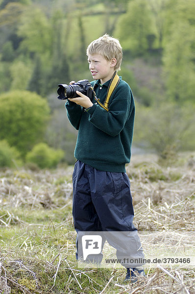 Boy taking pictures Dartmoor National Park Devon England