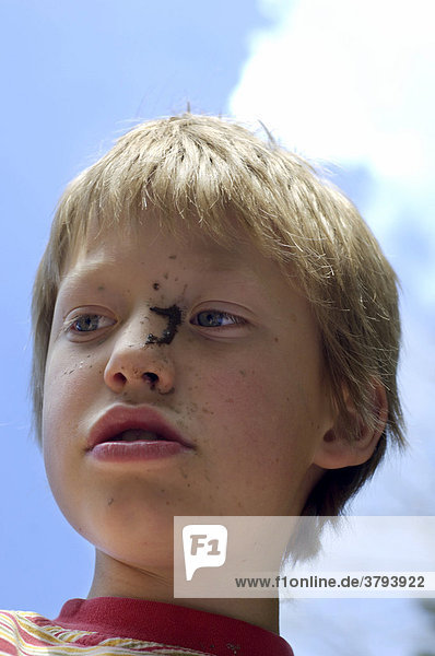 Neunjähriger Junge mit schmutzigem Gesicht