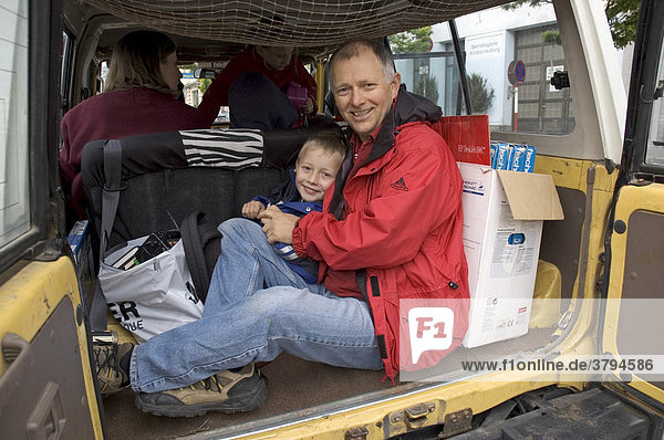 Father and six year old son in the back of a Toyota Landcruser 4 wheel drive in Klosterneuburg near Vienna Austria