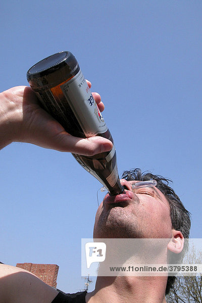 Man drinking beer out of a beer bottle