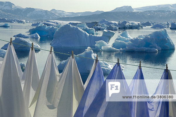 Wäsche hängt an Wäscheleine vor Eisbergen im Sermilik Fjord Tiniteqilaaq Ostgrönland