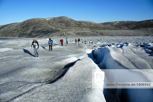 Hiking group on the inland ice shield with crevasse at Apuserserpia glacier Eastgreenland