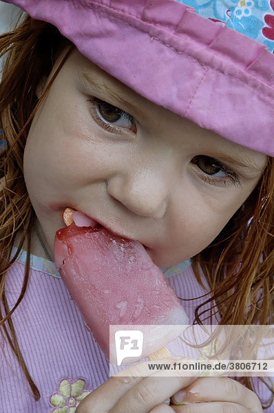 Mädchen 4 Jahre schleckt ein Eis im Sommer beim Eisschlecken