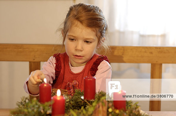 Kinder in der Vorweihnachtszeit im Advent mit Kerzen und Adventskranz