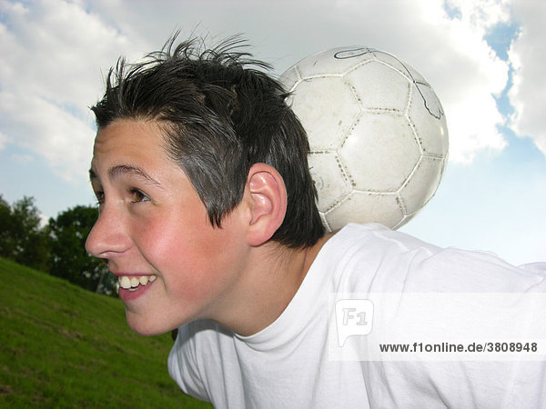 Teenager juggles with a ball