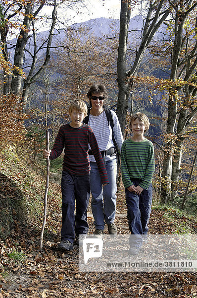 Mutter wandert im Herbst mit ihren beiden Söhnen auf dem Weg von Garmisch zum Eckbauer  Oberbayern  Bayern  Deutschland