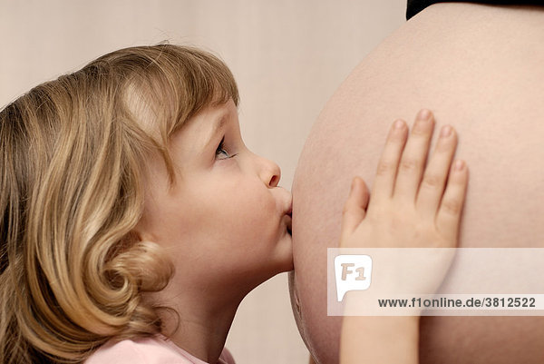 Little girl  4 years old  kissing the belly of her pregnant mother