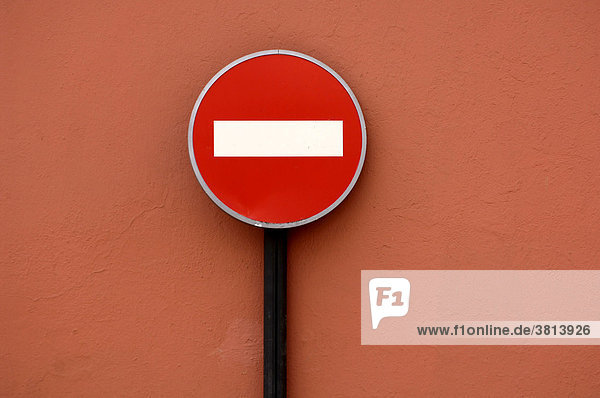 Traffic sign No Entry in front of red wall