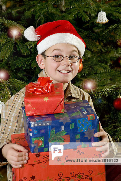 Ein zehnjaehriger Bube freut sich ueber Weihnachtsgeschenke