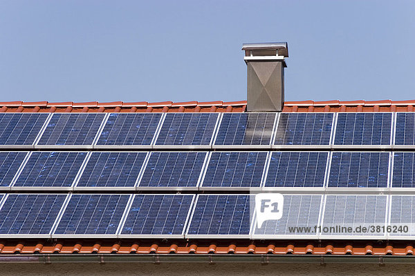 Das Dach eines Einfamilienhauses  das komplett mit Solarzellen bedeckt ist - ein Zeichen des Zeitgeistes