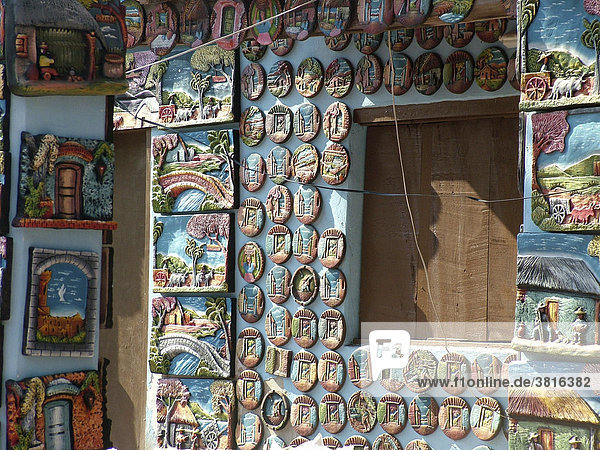 überfüllte Ausstellungswand mit bunten und kitschigen Tonbildern und Tontellern im Künstlerdorf Aregua bei Asuncion  Paraguay