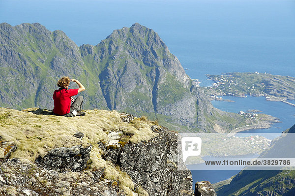 MR mountaineer enjoys the view from the summit of mountain Mannen Moskenesoya Lofoten Norway