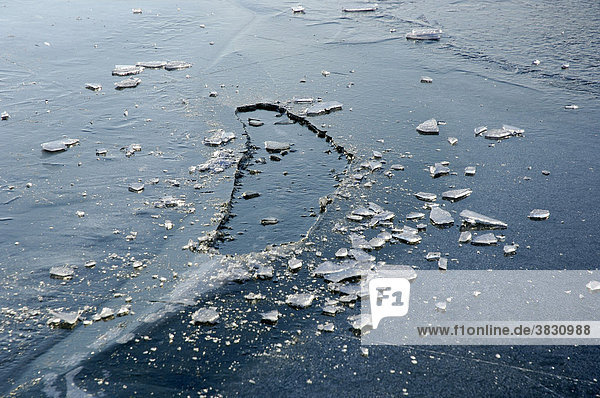 Wieder zugefrorenes Eisloch im See  gefrorenes Eis auf einem See