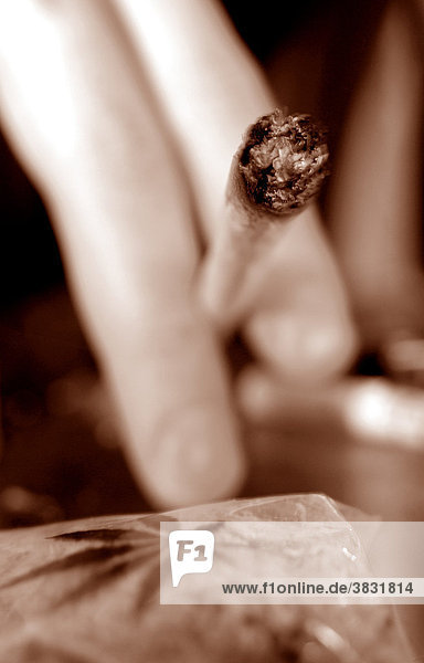 Pot smoker ! - Joint between fingers and a marijuana sac