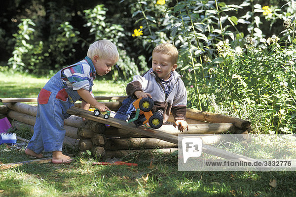 Two and two and a half year old boys playing in the garden MR