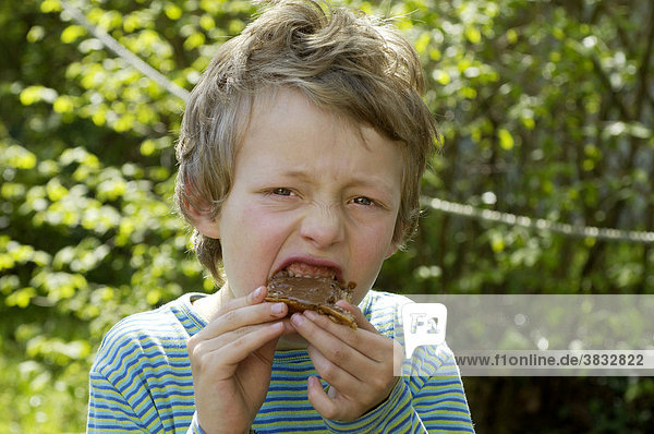 Ein siebenjähriger Junge isst Schokoladenbrot