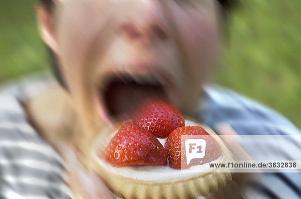 Frau isst Erdbeertörtchen