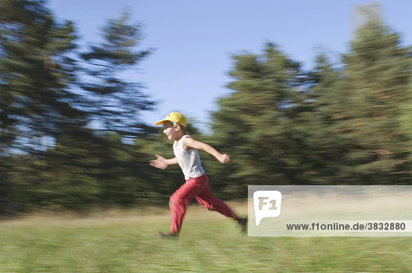 Six year old boy running with outstretched arms