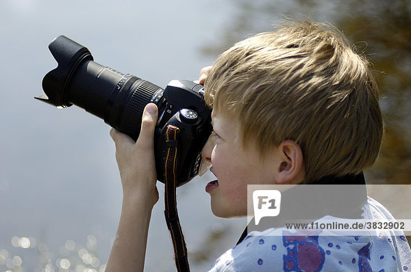 Zehn Jahre alter Junge fotografiert mit Spiegelreflexkamera